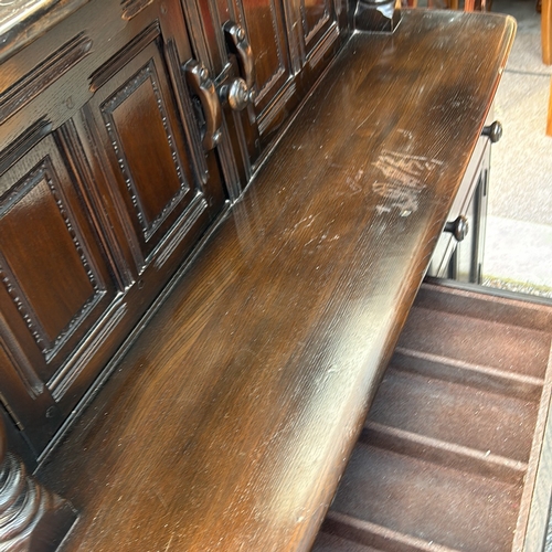 61 - Ercol dark wood sideboard features carved columns and paneled doors, offering ample storage. Ercol