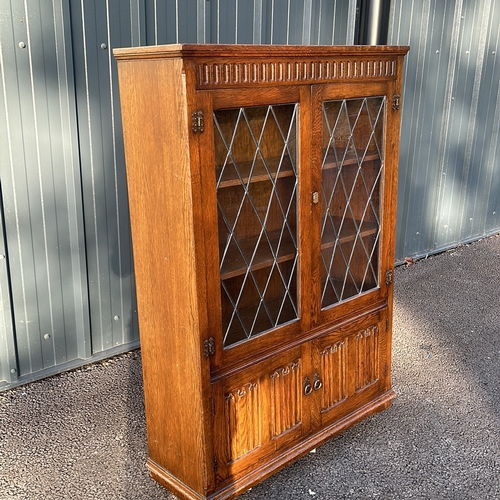 62 - Oak Art Nouveau bookcase with leaded glass doors, featuring carved decorative motifs from the early ... 