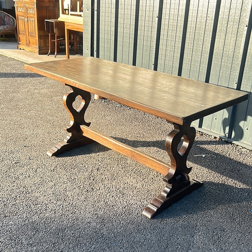 65 - Solid oak trestle table featuring a rectangular top and decorative carved base.