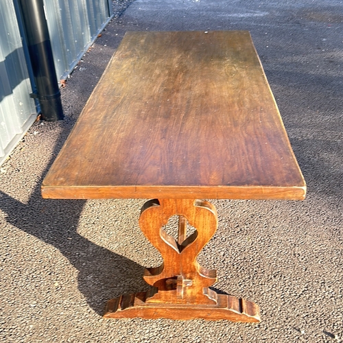 65 - Solid oak trestle table featuring a rectangular top and decorative carved base.