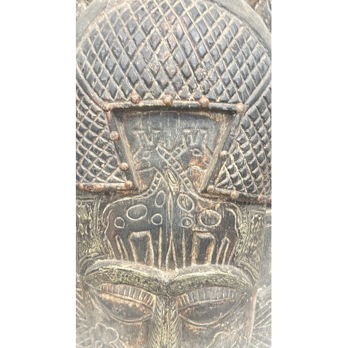 243 - Carved wooden tribal mask with intricate detailing, showcasing multiple faces and geometric patterns... 