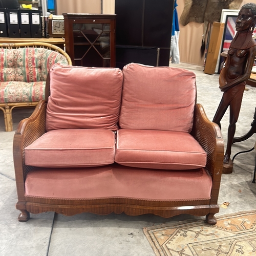 72 - bergere sofa with caned back and sides, featuring plush coral pink upholstery, displaying elegant ca... 