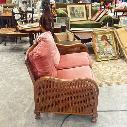 72 - bergere sofa with caned back and sides, featuring plush coral pink upholstery, displaying elegant ca... 