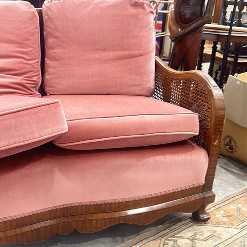 72 - bergere sofa with caned back and sides, featuring plush coral pink upholstery, displaying elegant ca... 