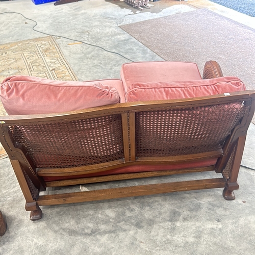 72 - bergere sofa with caned back and sides, featuring plush coral pink upholstery, displaying elegant ca... 