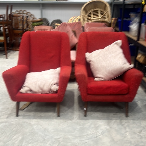 74 - Pair of Mid-Century Modern red upholstered armchairs with wooden legs, showcasing classic design ele... 