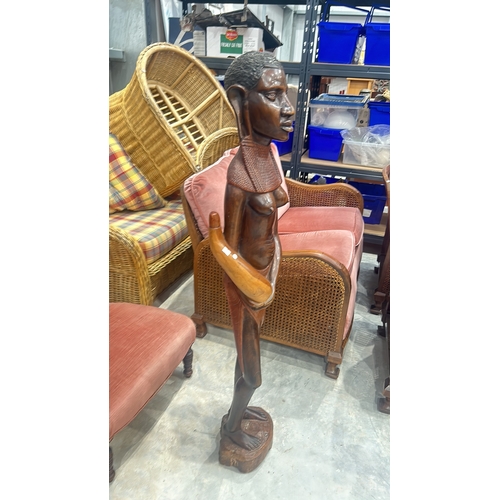 245 - Hand-carved wooden sculpture depicts a traditional African figure with intricate detail, standing on... 