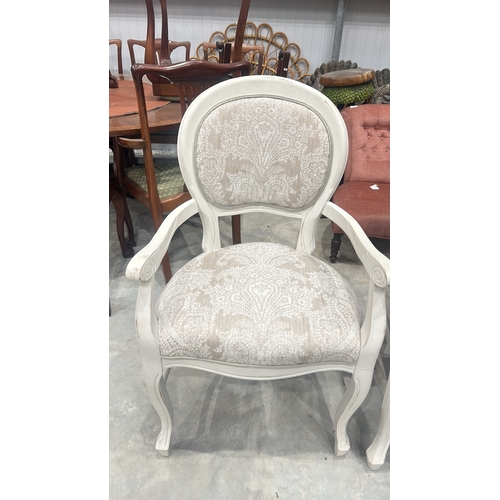 75 - Pair of white wooden armchairs with intricate scroll detailing and paisley-patterned upholstery.