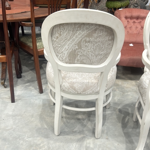 75 - Pair of white wooden armchairs with intricate scroll detailing and paisley-patterned upholstery.