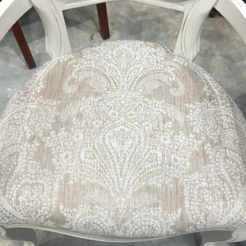 75 - Pair of white wooden armchairs with intricate scroll detailing and paisley-patterned upholstery.