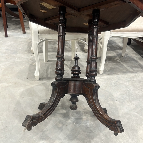 77 - Victorian walnut octagonal table features intricate marquetry inlay on top and elegant turned legs.