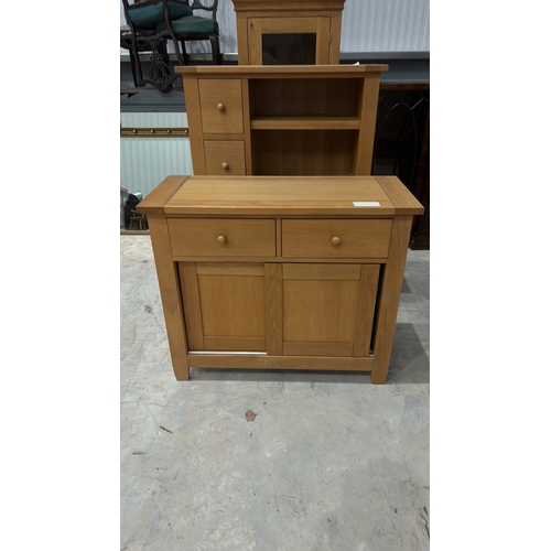 103 - Contemporary oak sideboard with sliding doors and shelving, featuring two drawers and minimalist des... 