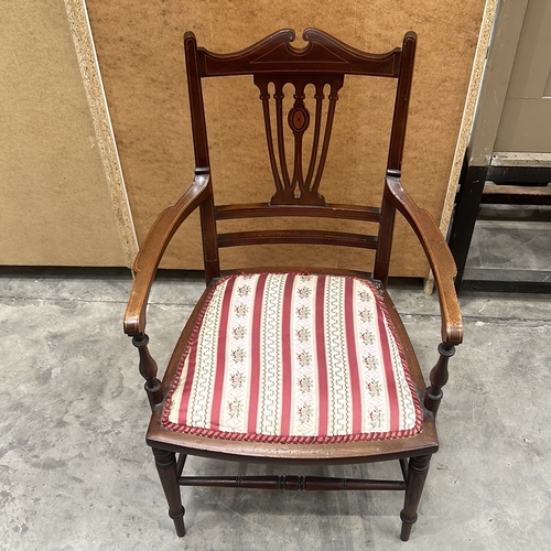 94 - Victorian mahogany armchair with intricate back detailing and upholstered seat.