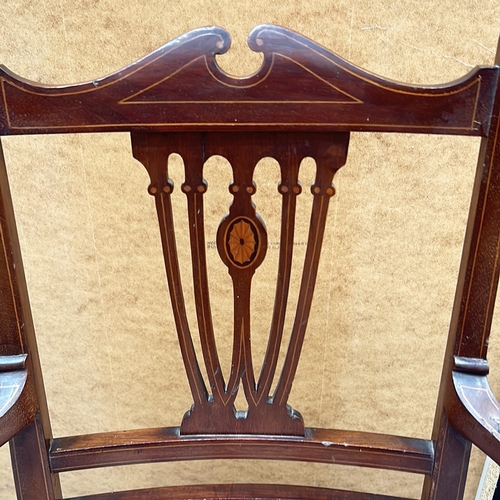 94 - Victorian mahogany armchair with intricate back detailing and upholstered seat.