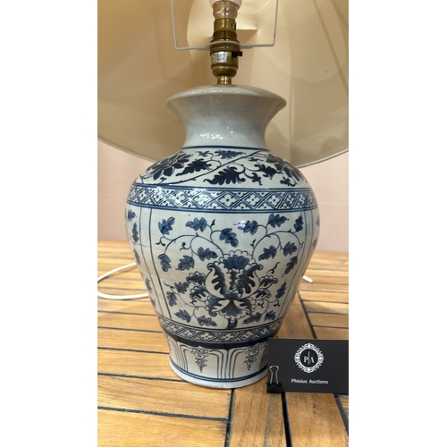 349 - Large Blue and white Chinese Ming Style ceramic lamp with floral motifs and a beige shade. It featur... 