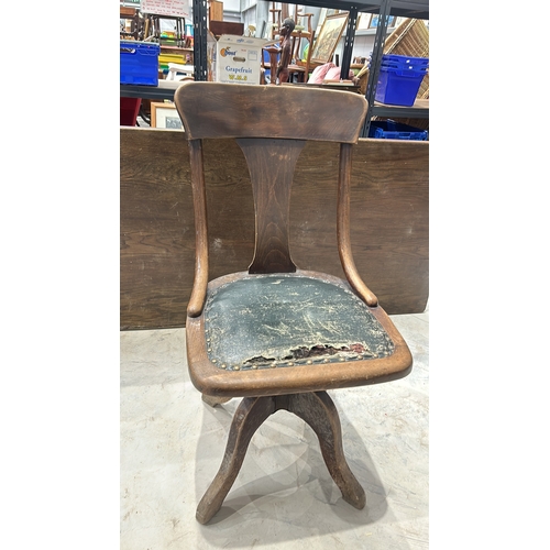 117 - Antique wooden swivel chair with a curved backrest, made from oak, featuring a distressed leather se... 