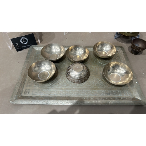 250 - A Collection of Persian/Indian Engraved brass items and a metal tray with six decorative bowls, feat... 