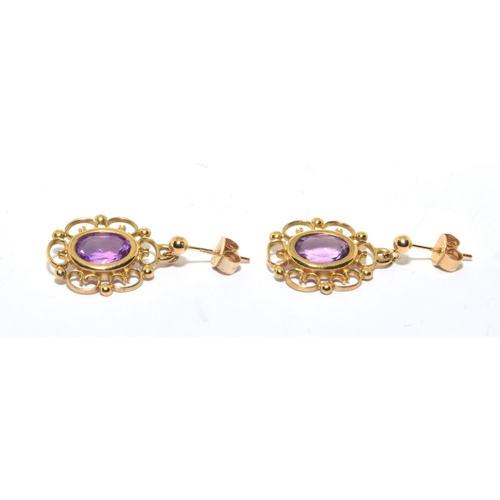 123 - 9ct gold Amethyst stud earrings in an openwork scroll setting 