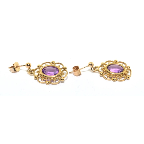 123 - 9ct gold Amethyst stud earrings in an openwork scroll setting 