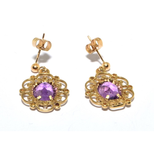 123 - 9ct gold Amethyst stud earrings in an openwork scroll setting 