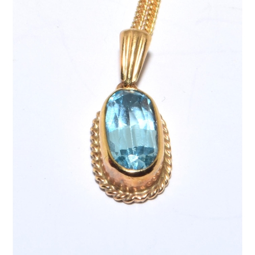 183 - 9ct gold Blue Topaz facetted oval pendant in an enclosed setting on a 44cm long chain 