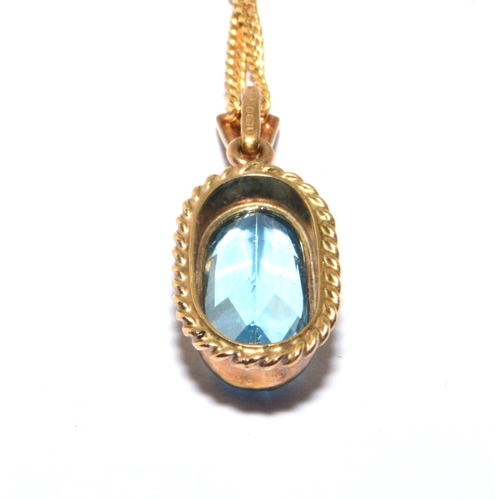 183 - 9ct gold Blue Topaz facetted oval pendant in an enclosed setting on a 44cm long chain 