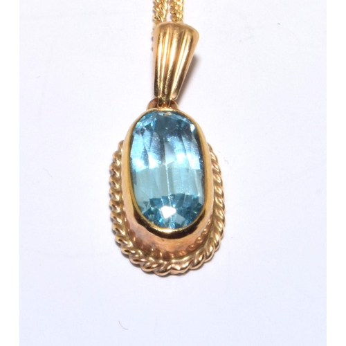 183 - 9ct gold Blue Topaz facetted oval pendant in an enclosed setting on a 44cm long chain 