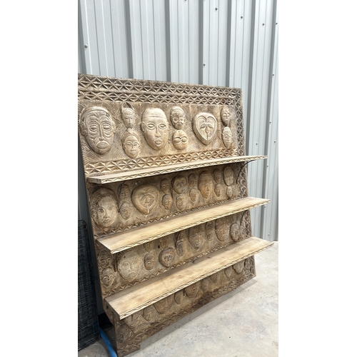 246 - Large African Carved wooden shelving unit with intricate tribal mask designs and geometric patterns.... 