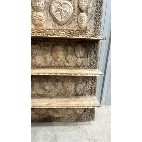 246 - Large African Carved wooden shelving unit with intricate tribal mask designs and geometric patterns.... 