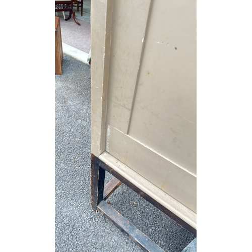 54 - Painted wooden panel, beige, with simple moldings. Mounted on an aged wooden stand featuring turned ... 