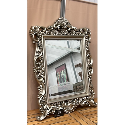 88 - Ornate silver-toned wall mirror with intricate floral design. Rectangular shape. Dimensions approxim... 