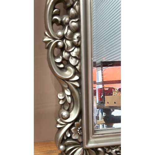 88 - Ornate silver-toned wall mirror with intricate floral design. Rectangular shape. Dimensions approxim... 