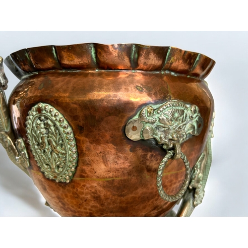 42 - A Chinese Tibetan Copper planter.Circa 1900.Mounted with metal Dragons, looped mask handles and deco... 