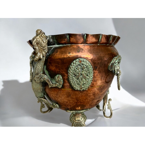 42 - A Chinese Tibetan Copper planter.Circa 1900.Mounted with metal Dragons, looped mask handles and deco... 