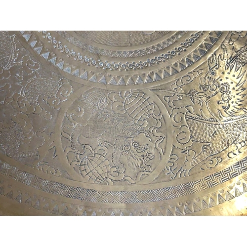 45 - A large Chinese brass top folding Benares table.The scalloped brass tray engraved with entwined Drag... 