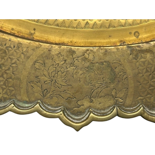 45 - A large Chinese brass top folding Benares table.The scalloped brass tray engraved with entwined Drag... 