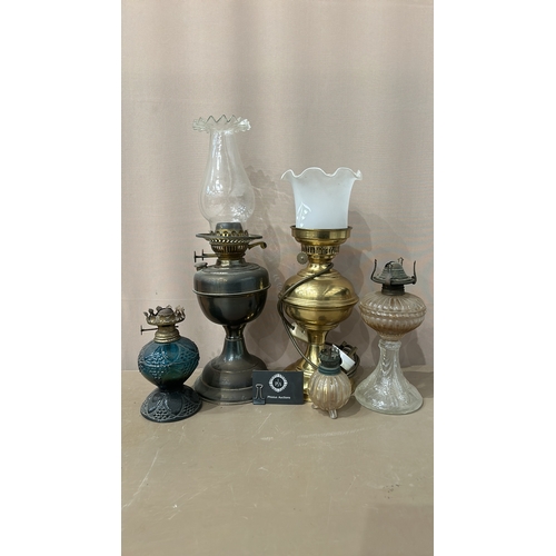 163 - Collection of six vintage oil lamps, featuring ornate glass and brass designs—an eclectic mix showca... 