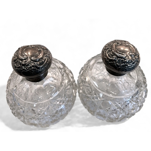 560 - A pair of Edwardian silver mounted crystal cut perfume bottles.Height - 11.5cm