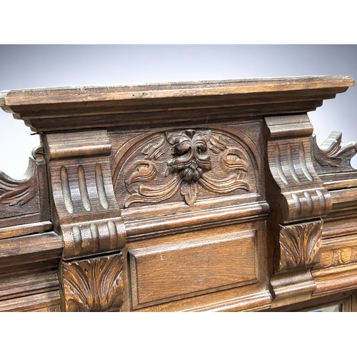 279 - A large carved Oak 'Green man' bevelled mirror.Supported by twin columns.