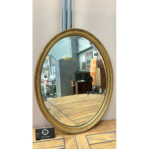 43 - Oval gilt-framed mirror with ornate beaded edge detailing. Sturdy metal hanging fixture on back.