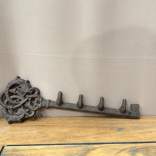 45 - Ornate cast iron wall hook in key shape, featuring five hooks. And a cast iron door stop in the form... 