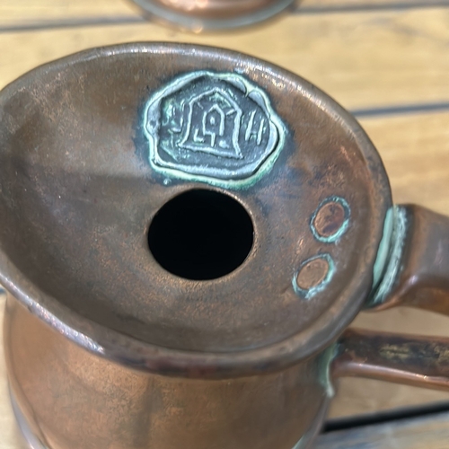 53 - Set of four graduated copper measuring jugs with handles, marked for pint, gill, half gill, and quar... 