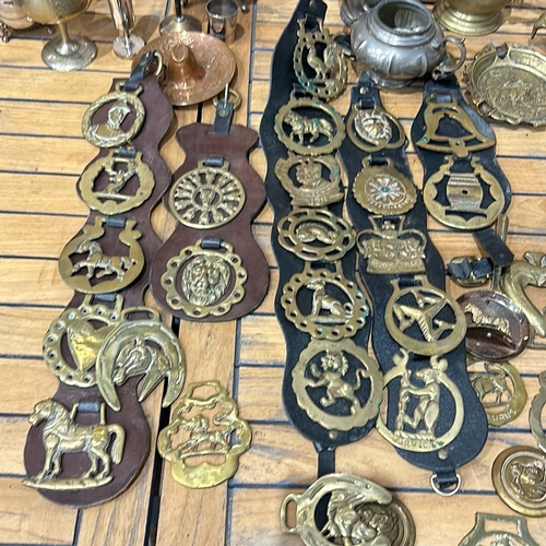 55 - Collection of vintage brass horse brasses on leather, alongside assorted metalware including teapots... 