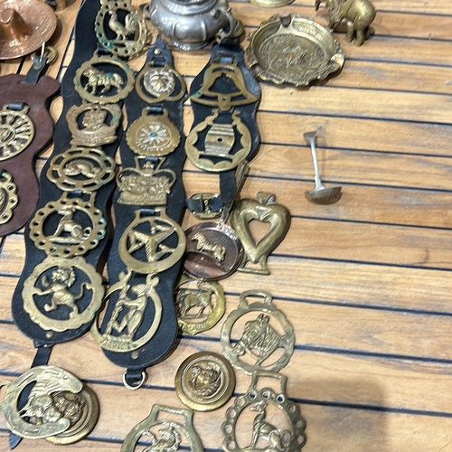 55 - Collection of vintage brass horse brasses on leather, alongside assorted metalware including teapots... 