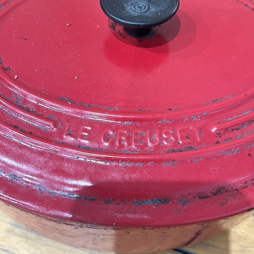 57 - Le Creuset cast iron Dutch ovens, two pieces, enameled in red and orange. Renowned for heat retentio... 