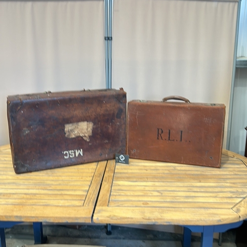 58 - Vintage leather suitcases with sturdy handles, brass clasps, and original interior linings. Features... 