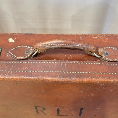 58 - Vintage leather suitcases with sturdy handles, brass clasps, and original interior linings. Features... 