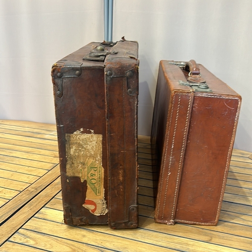 58 - Vintage leather suitcases with sturdy handles, brass clasps, and original interior linings. Features... 