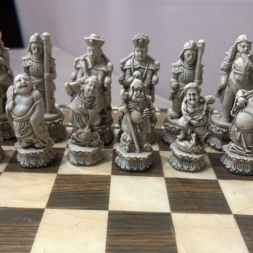 62 - Intricately carved Chinese chess set with detailed figurine pieces on a decorative inlaid board, fea... 