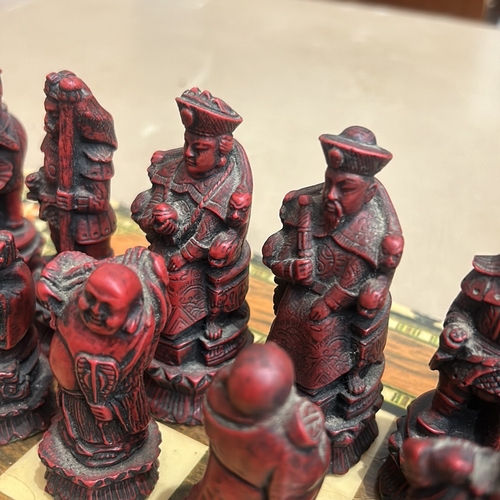 62 - Intricately carved Chinese chess set with detailed figurine pieces on a decorative inlaid board, fea... 